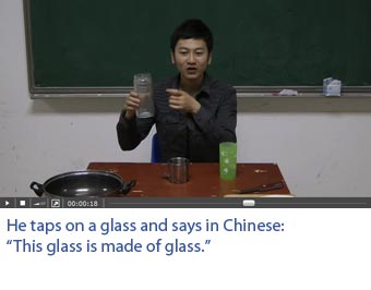 Screenshot of a video with professional Chinese actors on which one sees what he hears. He taps on a glass which produces a sound of glass. He says in Chinese: This glass is made of glass.